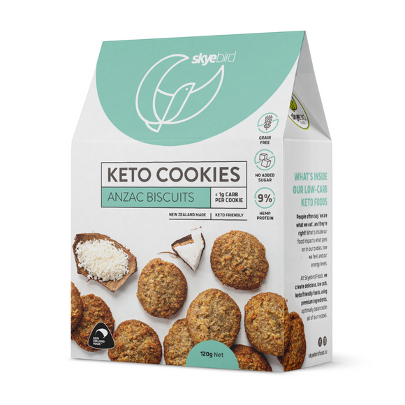 Picture shows box of Chewy Keto ANZAC cookies with a number of keto ANZAC cookies on the front of the package with a Skyebird Foods company logo with a blue background on the front of the box of keto cookies. There's a prominent NZ made icon at the bottom of the keto cookie box to show the keto cookies are nz made. 